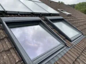 Person sägt mit einer Elektrosäge Holz aus einer Dachschräge