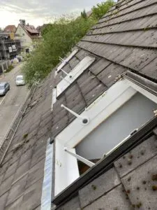 Frisch abgedichteter Dachbalkon mit Metallgeländer und Blick auf die Nachbarhäuser