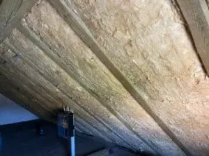 Dämmplatten zwischen den Holzsparren eines nicht ausgebauten Dachbodens