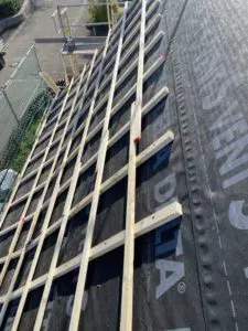 Diagonal verlegte Holzlatten auf einer Dachunterspannbahn