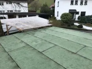 Begrüntes Flachdach mit Blick auf Häuser, Garten und Carport