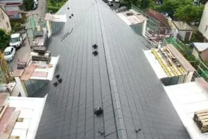 Großes schwarzes Metalldach im Bau, beidseitig eingerüstet, von oben