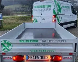 Transporter mit Anhänger und Aufschrift „Wollmerstedt Dachdeckerei“